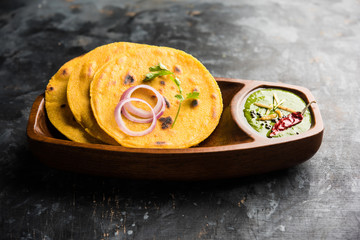 Makki di roti with sarson ka saag, popular punjabi main course recipe in winters made using corn breads mustard leaves curry. served over moody background. selective focus
