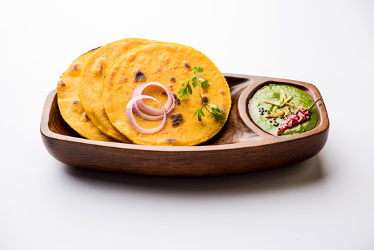 Makki di roti with sarson ka saag, popular punjabi main course recipe in winters made using corn breads mustard leaves curry. served over moody background. selective focus