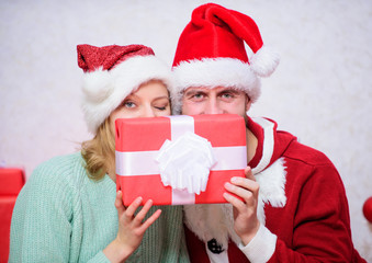 Couple in love enjoy christmas celebration. It is easy to spread happiness around. Happy family celebrate christmas. Christmas gift concept. Couple wear hats as santa claus christmas tree background