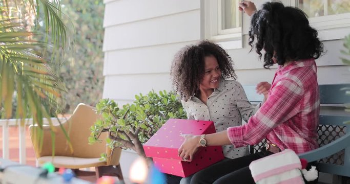 African American mother giving daughter a christmas gift