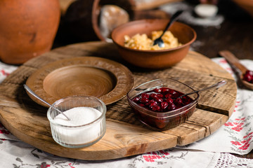 cherry jam in a vase on a wooden background