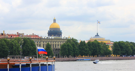 St. Petersburg summer cityscape with Saint Isaac's Cathedral Dome, view from Neva river embankment with russian flag