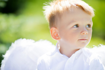 Adorable toddler boy in angel costume, angelic child.