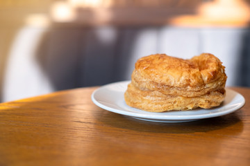 Whole cooked pie with a pair of mushrooms on wooden background