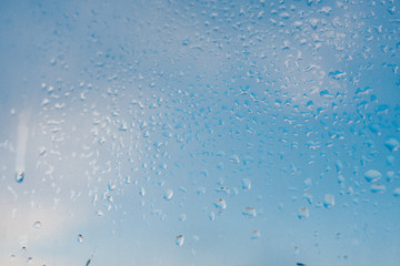 Misted glass background. Strong humidity in wintertime. Water drops from home condensation on a window