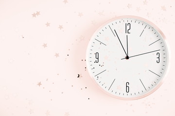 Obraz na płótnie Canvas Winter composition. New year clock and decorationson pastel pink background. Christmas, New Year, winter concept. Flat lay, top view, copy space