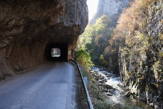 Old rural road with handmade tunnels.
Curvy road through tunnel in canyon of river Jerma