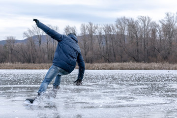 Man falling down while ice skating. Snow skates from the scatter in the parties.