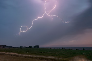 A bright lightning bolt in the clouds during a severe thunderstorm in Holland