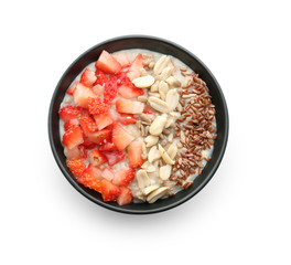 Bowl with tasty oatmeal, strawberry and nuts on white background