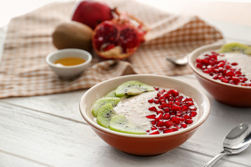 Plates with tasty oatmeal and fruits on white wooden table