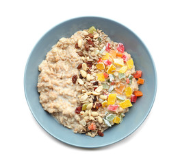 Plate with tasty oatmeal, nuts and succades on white background