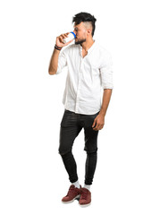A full-length shot of a Arabic young man with white shirt holding hot coffee in takeaway paper cup on isolated white background