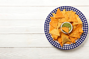 Tasty corn chips with sauce on plate