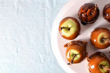 Delicious caramel apples with tree branches on stand