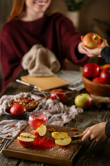 Woman cutting fresh apple at wooden table