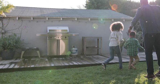 African American family playing football in yard