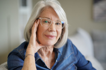  Attractive senior woman at home with eyeglasses