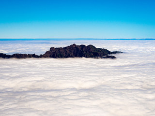 Mountain peak emerging from a sea of clouds