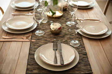 Fototapeta premium Elegant Dining Table Setting with Modern Dinnerware and Gold Accents