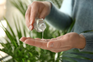 Woman using antibacterial hand gel, closeup
