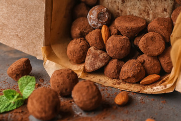 Overturned box with tasty chocolate truffles on grey table