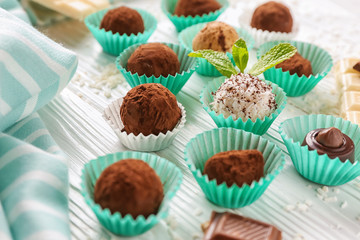 Different tasty chocolate truffles on light table
