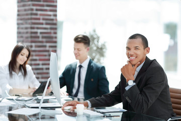 young businessman sitting behind a Desk in a modern office.