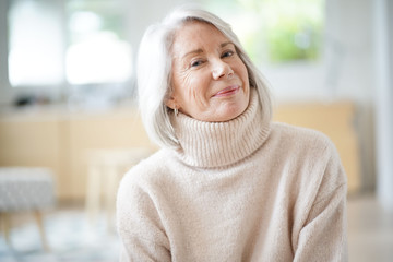 Happy senior woman sitting at home