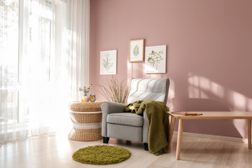 Interior of light room with cozy armchair near window