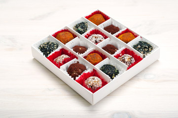 Extra vegan (raw food) sweets from dried fruits, nuts, seeds, spices and seasonings in a white box...