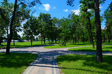 Long road in the green beautiful summer Park of the city.