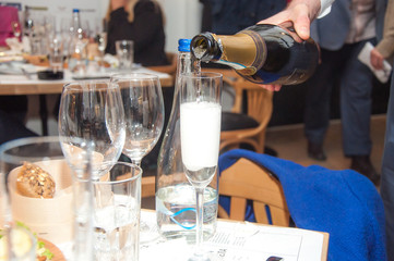 Pouring sparkling champagne into a crystal glass in restaurant