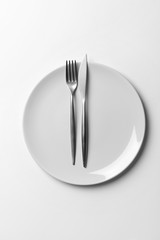 Plate with cutlery on white background