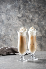 Glasses of cold frappe coffee on grey table
