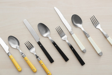 Set of cutlery on light wooden background, flat lay