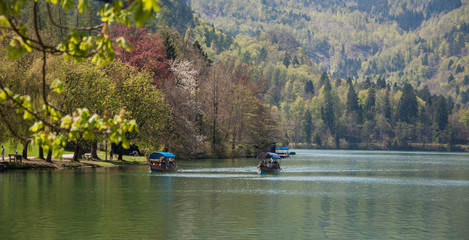 View of Lake Bled with pleasure boats on a sunny day in Slovenia