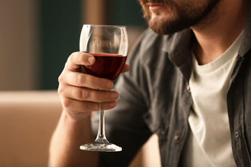Man drinking wine at home, closeup
