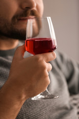 Man drinking wine at home, closeup