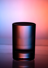 Glass with water on a dark colorful background