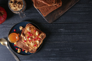 Plate with sweet toasts and jam on wooden table
