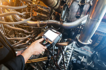 Fototapeta premium Inspection of a gas turbine engine using a Video Endoscope. Search for defects inside the turbine and shooting on video, photos using a measuring instrument.
