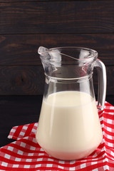 Milk in a jug on dark boards place for text copy space