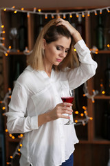 Upset woman with glass of wine in bar