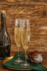 Glasses and bottle of champagne on wooden background