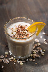 creamy cocktail with oats on dark background, vertical top view