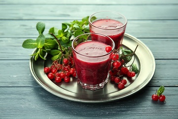 Glasses of tasty red smoothie on metal tray