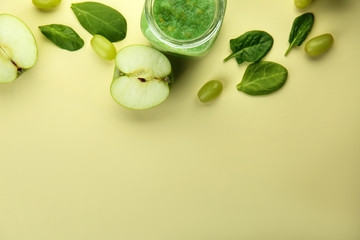 Mason jar of tasty green smoothie on color table