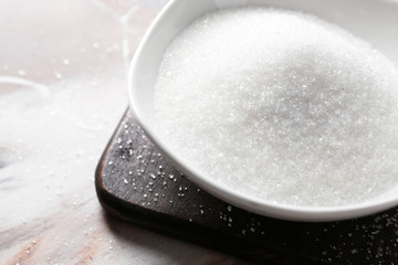 Plate with sugar on wooden board