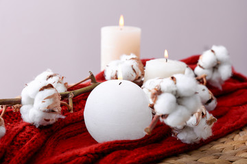 Burning candles and cotton flowers on table